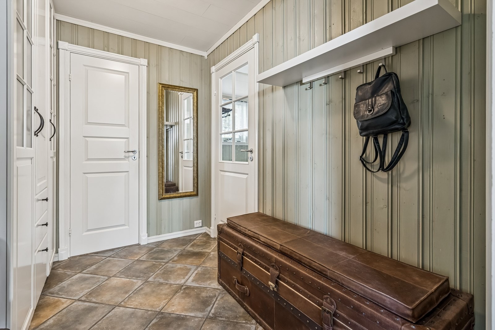 Gangen har formpressede innerdører fra 2011 og malt trepanel på veggene. Galleribilde