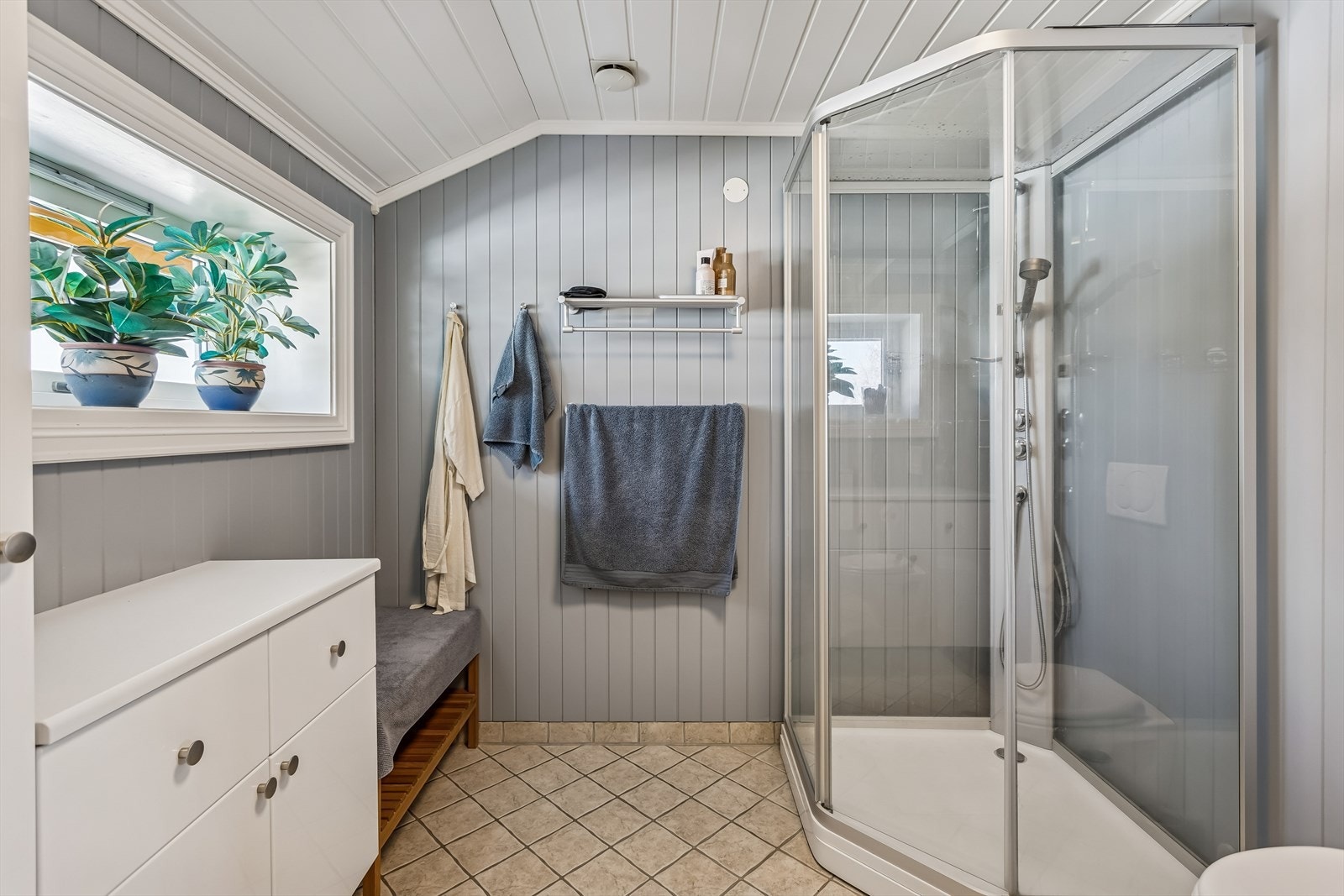 Her er det elektrisk gulvvarme for økt komfort, samt et praktisk dusjkabinett. Galleribilde