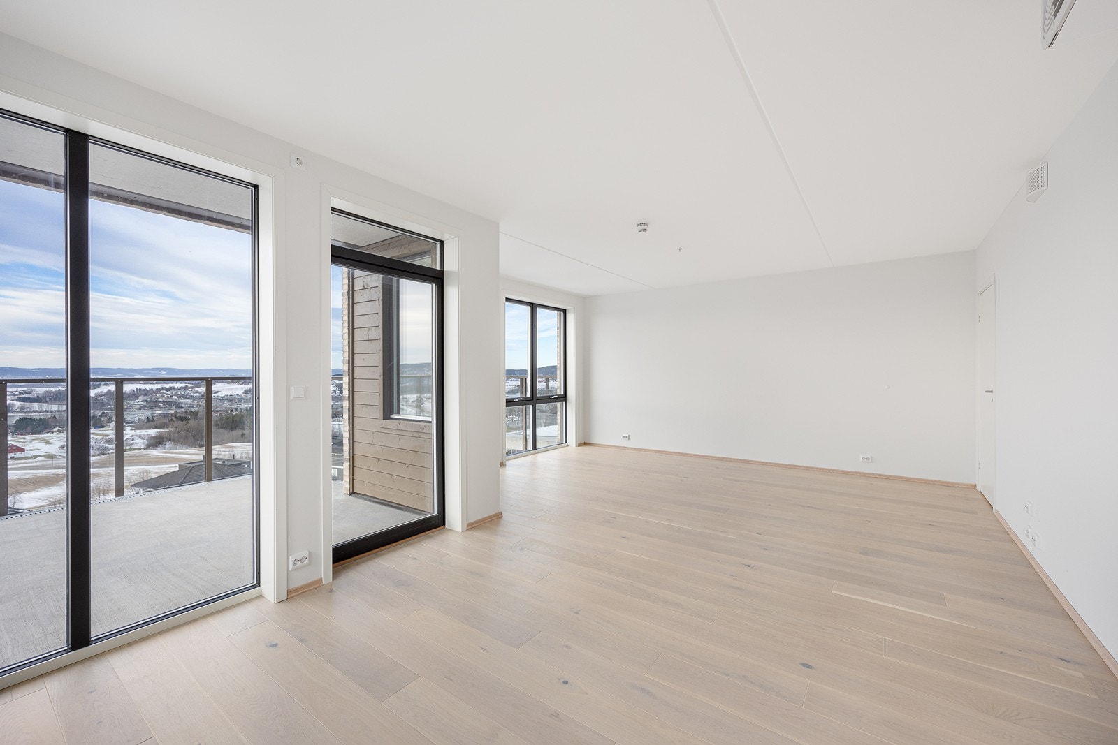 Store vindusflater gir rikelig med naturlig lys og utsikt mot landskapet. Utgang til balkong gir enkel tilgang til uteområdet fra stuen. Galleribilde