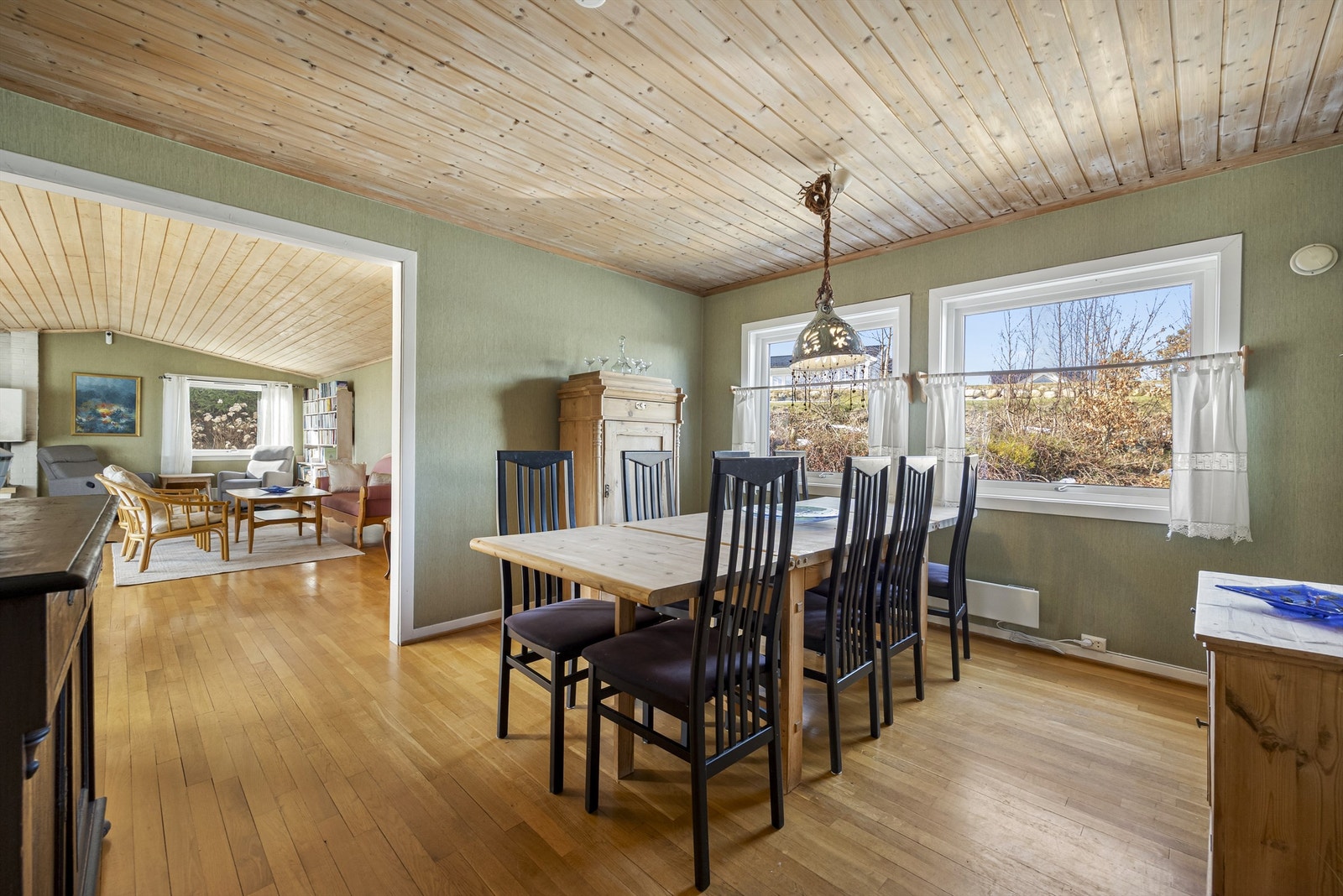 Spisestue med store vindusflater og åpen løsning til hovedstua. Det er god plass til et stort spisestuebord. Galleribilde