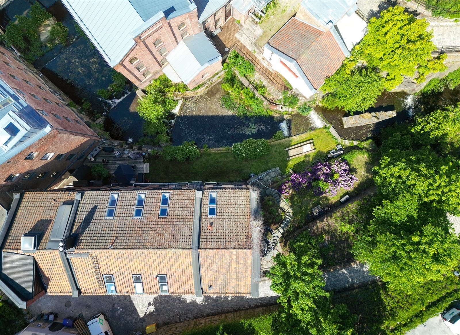 Det utvendige fellesarealet har pent opparbeidet bakhage. Galleribilde