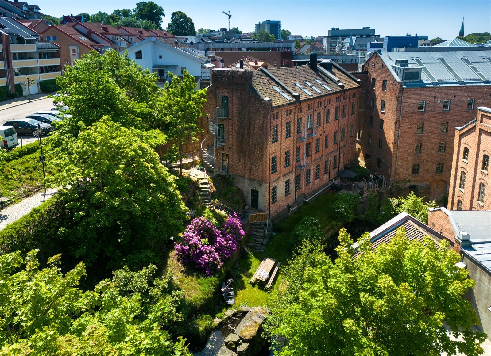 Mellom de gamle møllebygningene skjuler det seg en oase - nyt grønne omgivelser og sildring fra fossen rett utenfor. Galleribilde