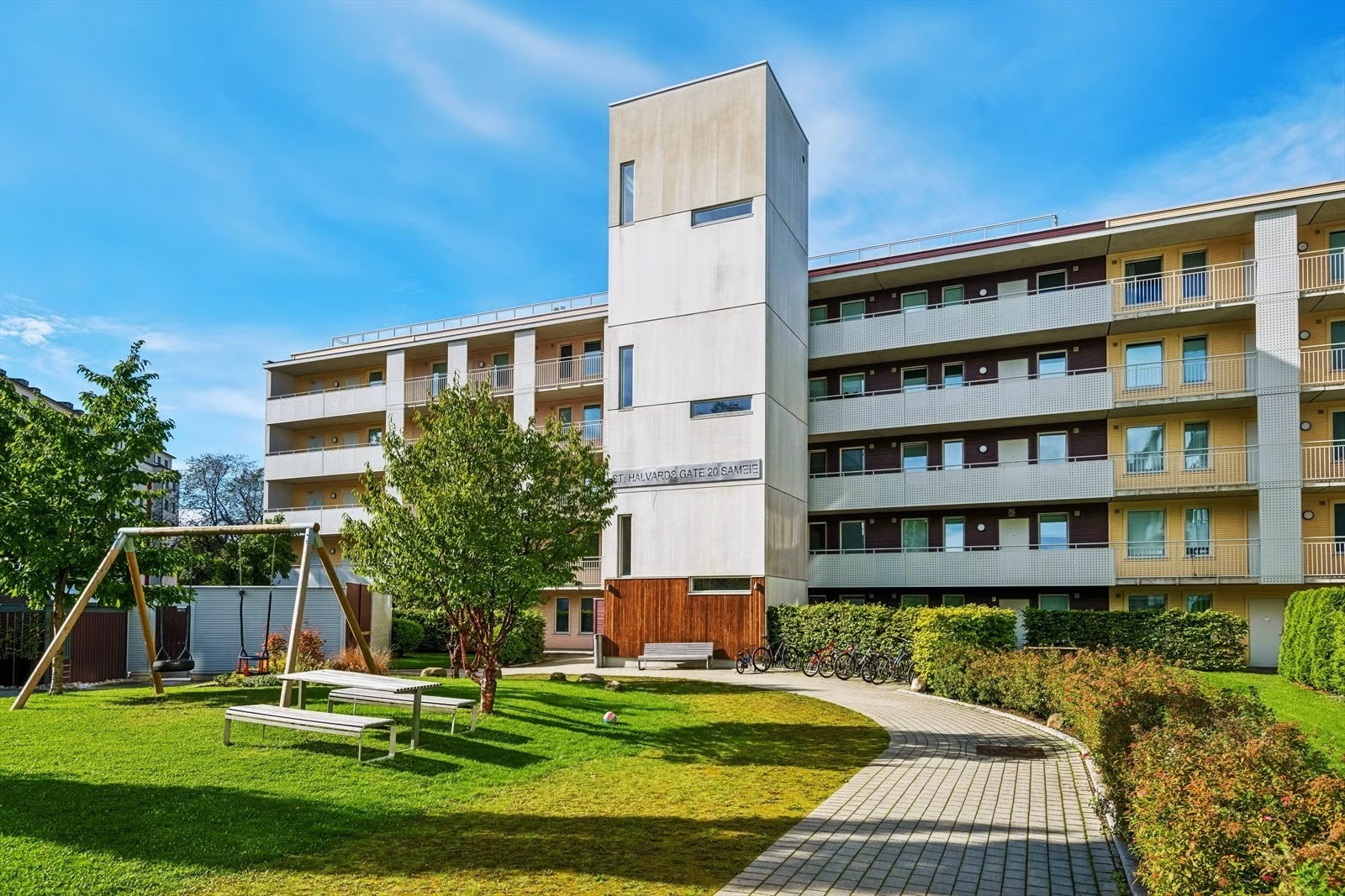 Fellesarealet er opparbeidet med sittegrupper, lekeapparater, beplantning og plen Galleribilde