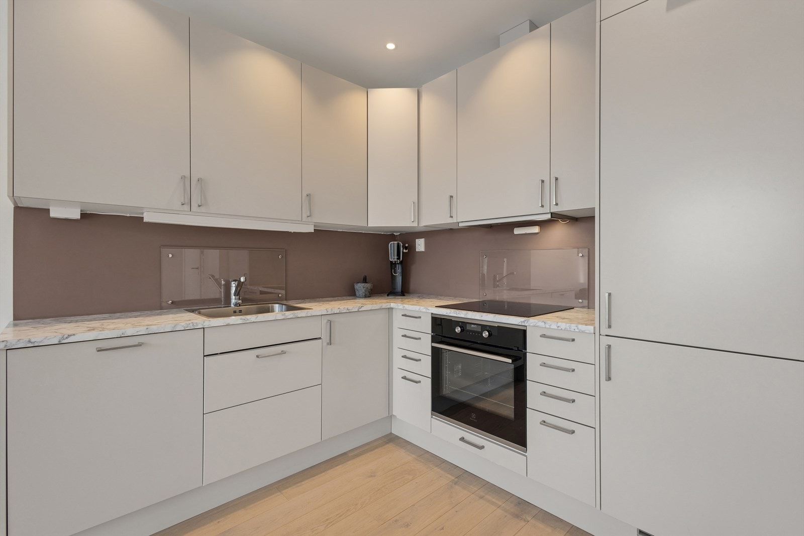 Moderne og stilrent kjøkken som er utstyrt med integrerte hvitevarer som kjøl/frys, oppvaskmaskin, platetopp og stekeovn. Galleribilde