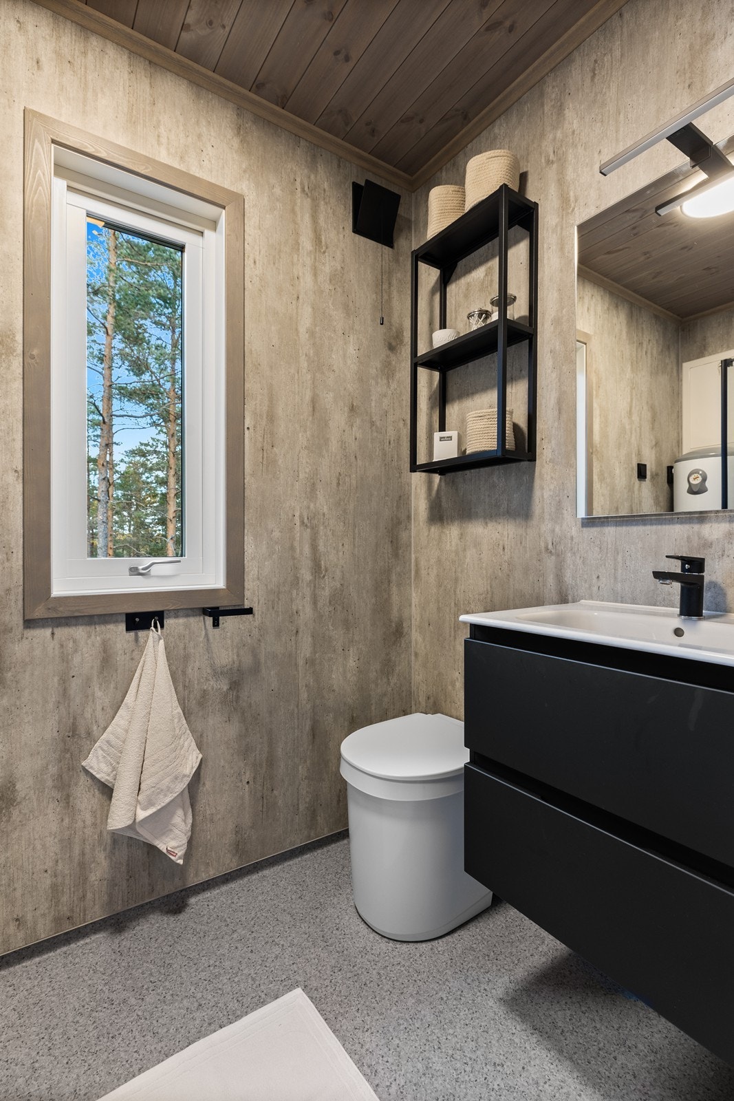 Badet har belegg på gulv, våtromsplater på vegg og trepanel i himlinger Galleribilde