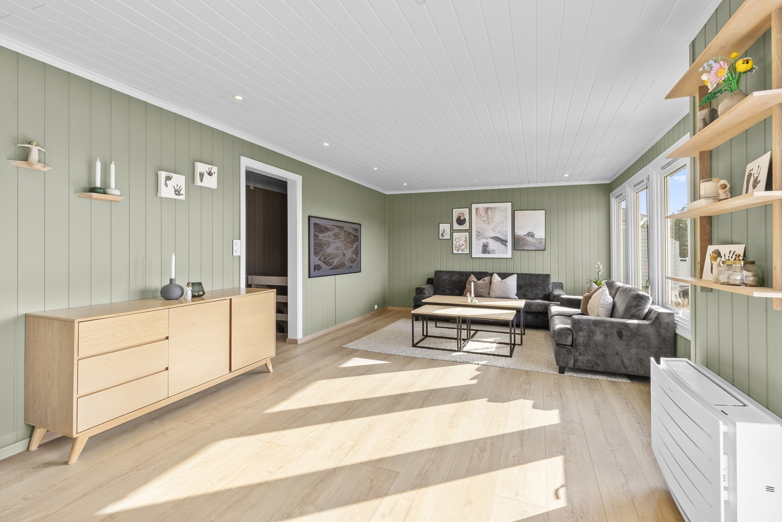 Stuen har store vindusflater som slipper inn rikelig med naturlig lys og er malt i delikate farger Galleribilde