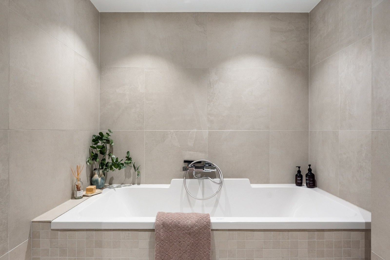 Rommet er utstyrt med vegghengt servant, speil med integrert belysning, vegghengt toalett, badekar og dusj. Galleribilde