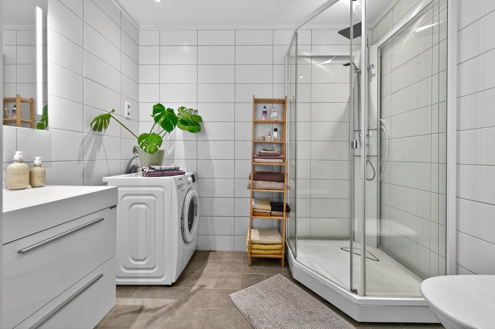 Pent flislagt baderom med vannbåren varme i gulv og opplegg til vaskemaskin Galleribilde