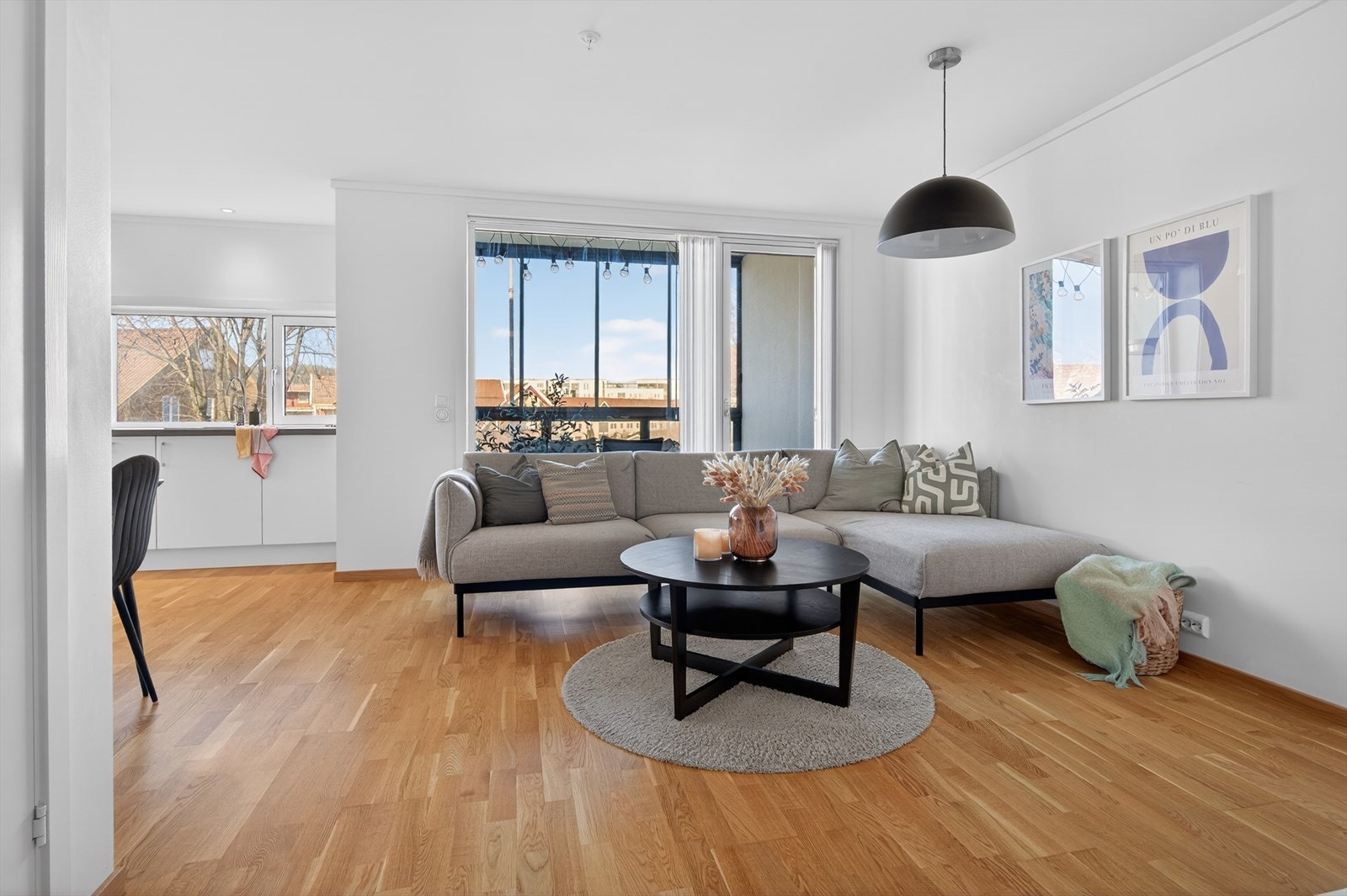 Leiligheten har en lys og luftig stue med store vinduer som sørger for godt med naturlig lys inn Galleribilde