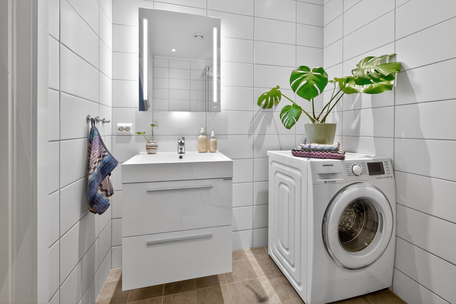 Baderom inneholder servant, innredning, speil, dusjkabinett og vegghengt wc Galleribilde