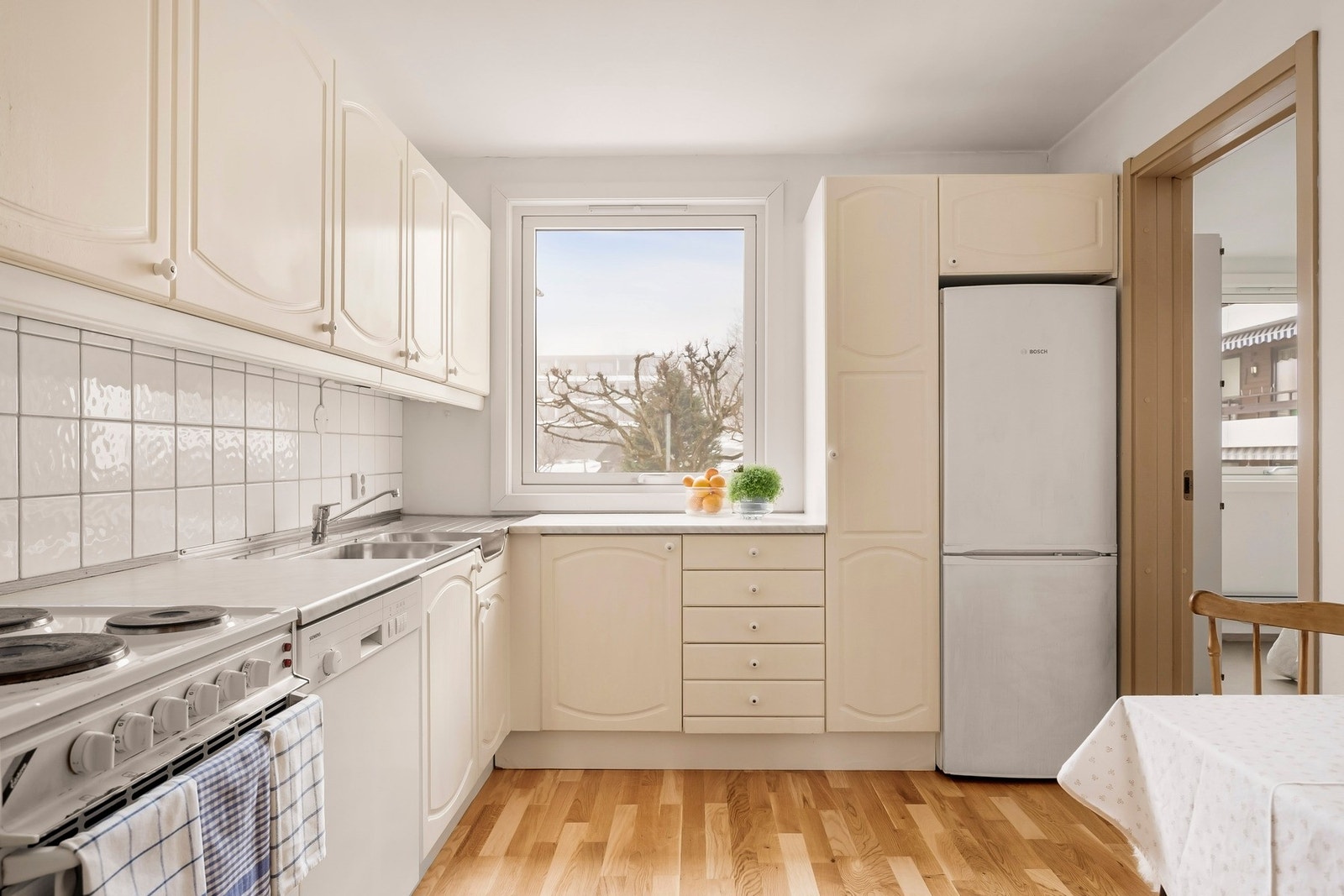 Kjøkkeninnredning med laminerte skrog, slette fronter og benkeplate av laminat med oppvaskkum i sink. Galleribilde