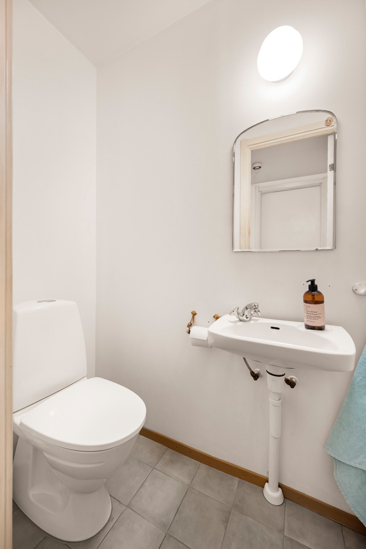 På motsatt side av gangen finner du et toalettrom med gulvstående toalett, servant og speil på vegg. Galleribilde