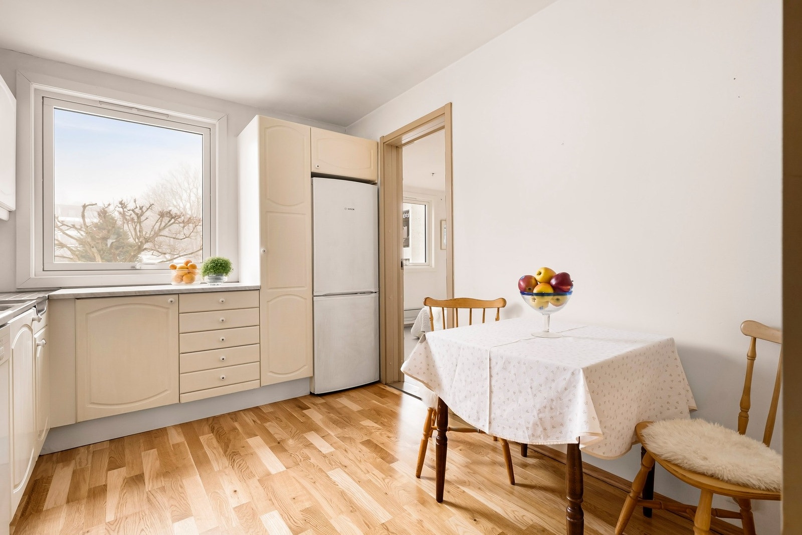 Leiligheten har et separat kjøkken med vindu og plass til et spisebord og stoler. Galleribilde