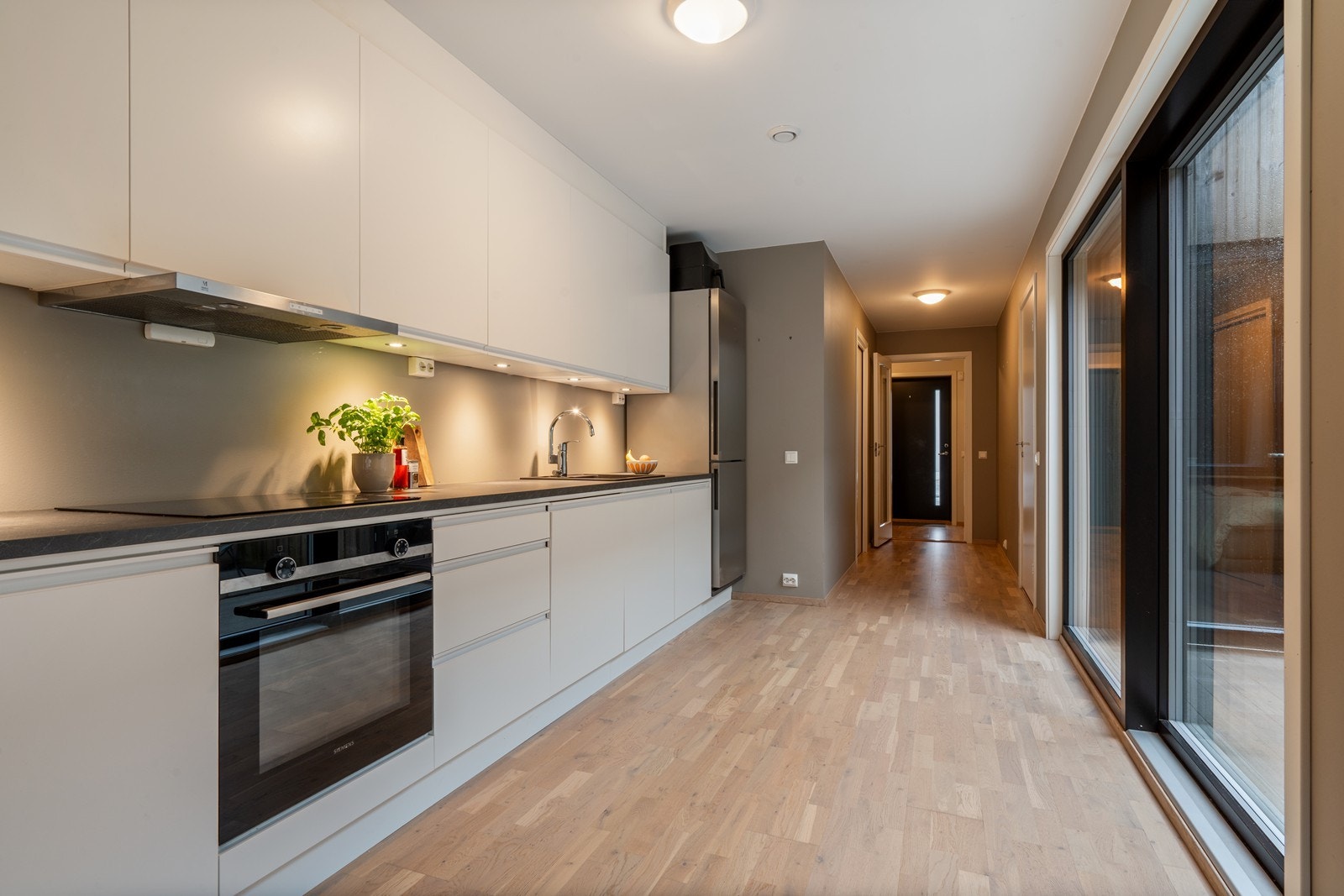 Integrerte hvitevarer som oppvaskmaskin, stekeovn og platetopp, samt frittstående kombiskap Galleribilde