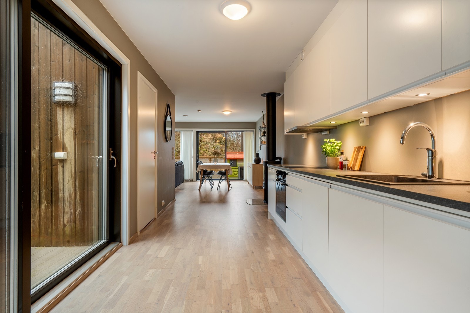 Kjøkkenet ligger i åpen løsning mot stuen og har en praktisk utforming. Kjøkkeninnredningen er et stilrent Drømmekjøkken Galleribilde