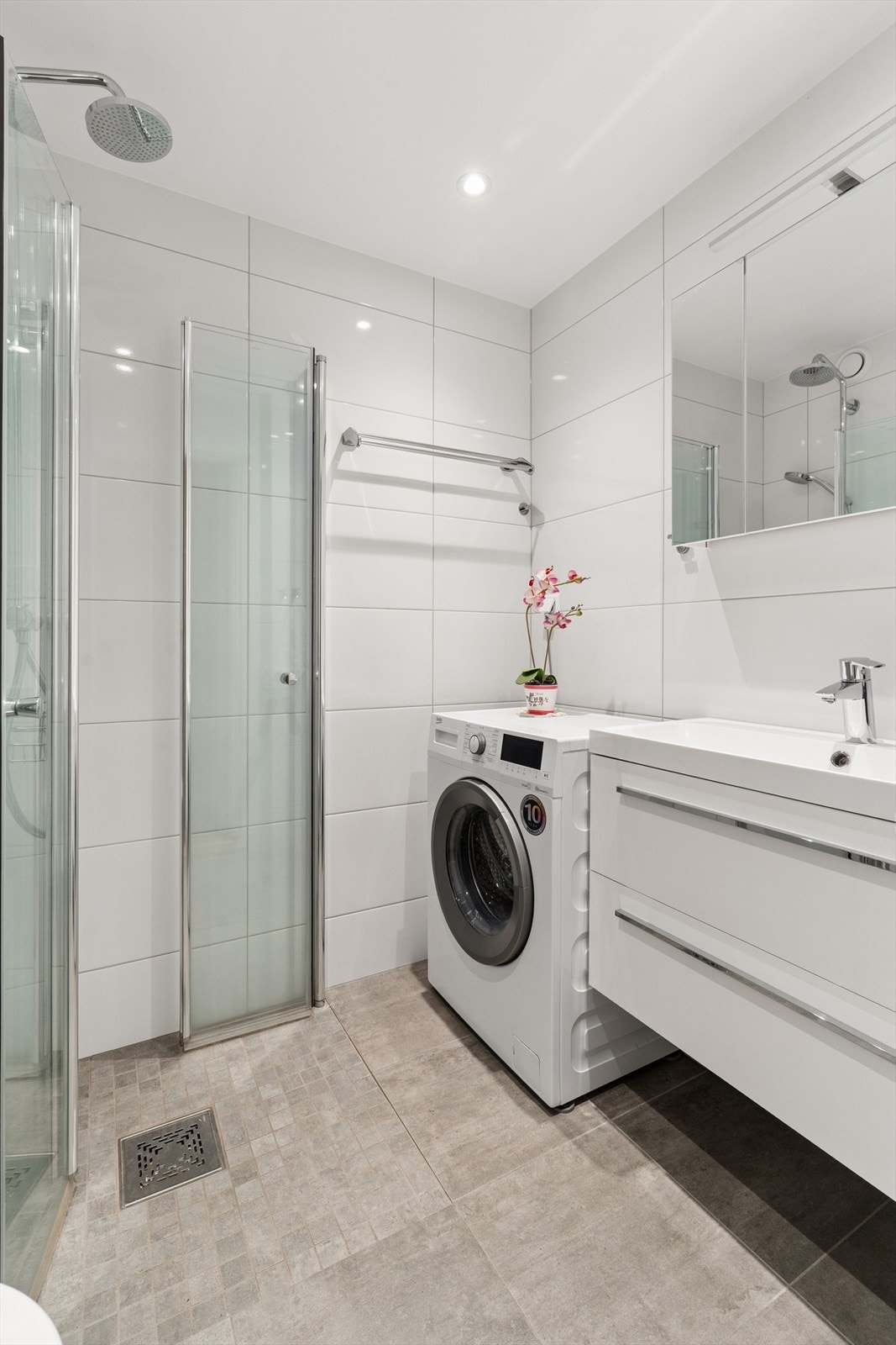 Lyst og innbydende bad fra 2021 med flislagte overflater. Galleribilde