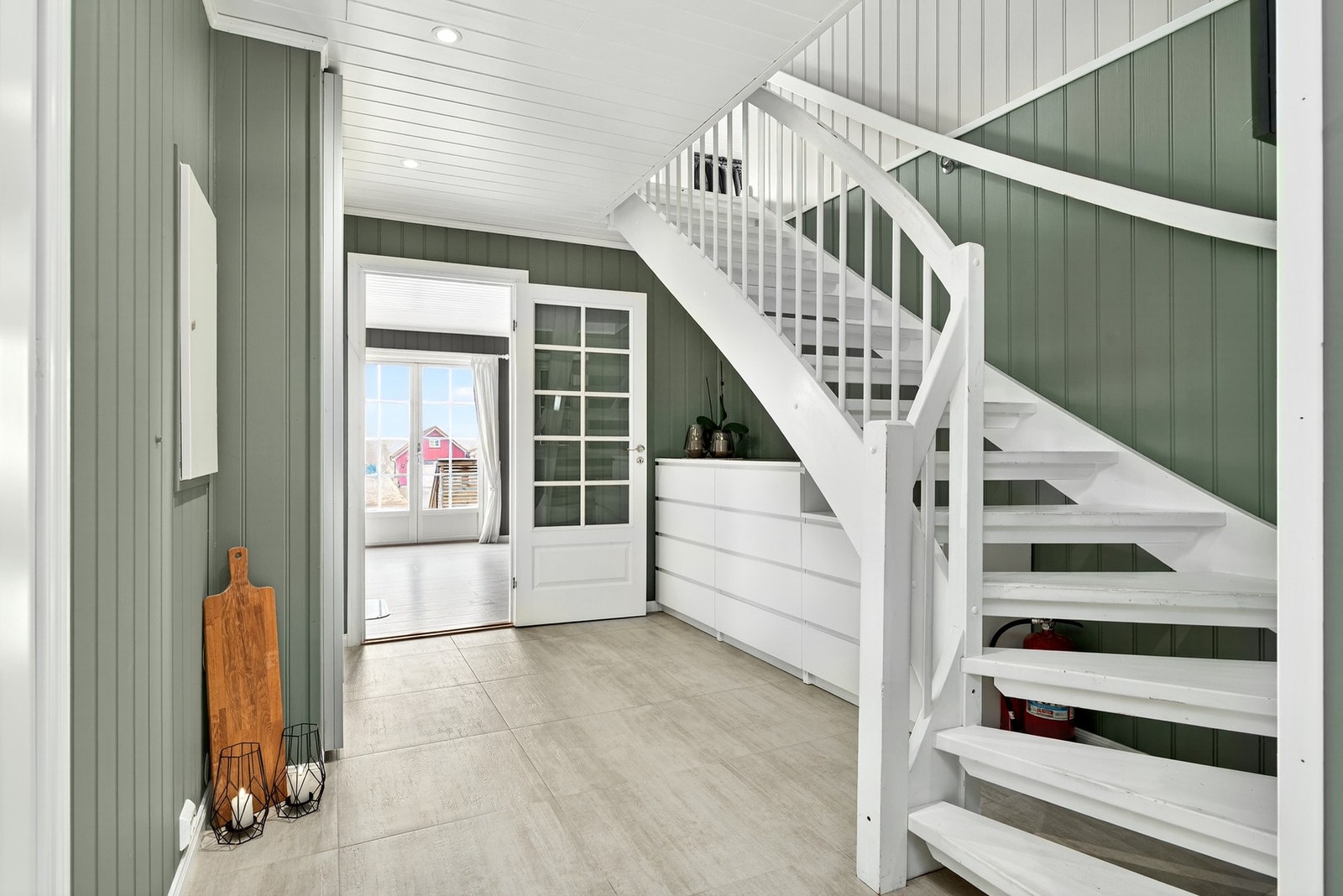 Innbydende gang i grønn tone med trapp til 2. etasje og adkomst til stue og kjøkken. Galleribilde