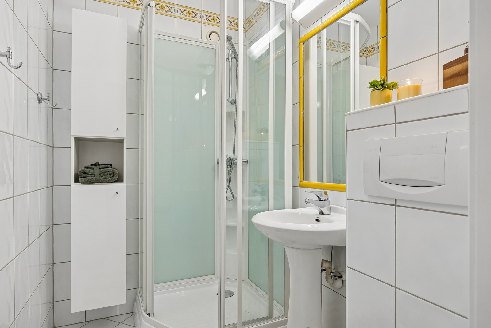 Flislagt bad med dusjkabinett og vegghengt toalett. Galleribilde