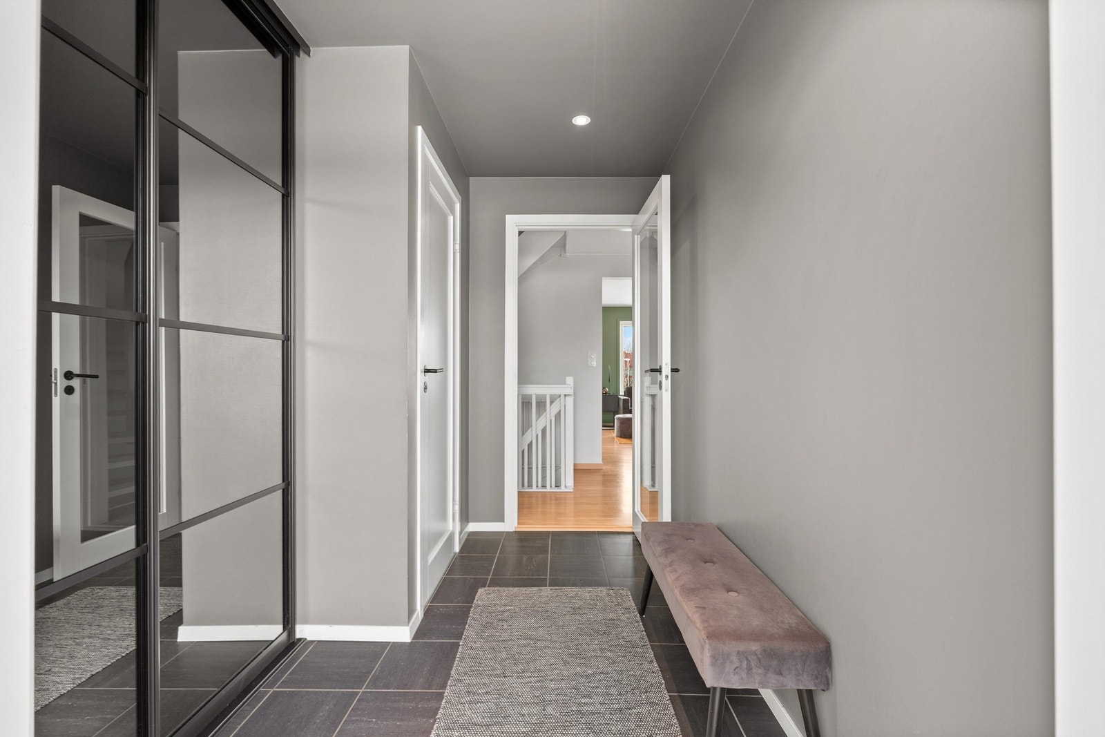 Flislagt entre med stor skyvedørsgarderobe. Galleribilde