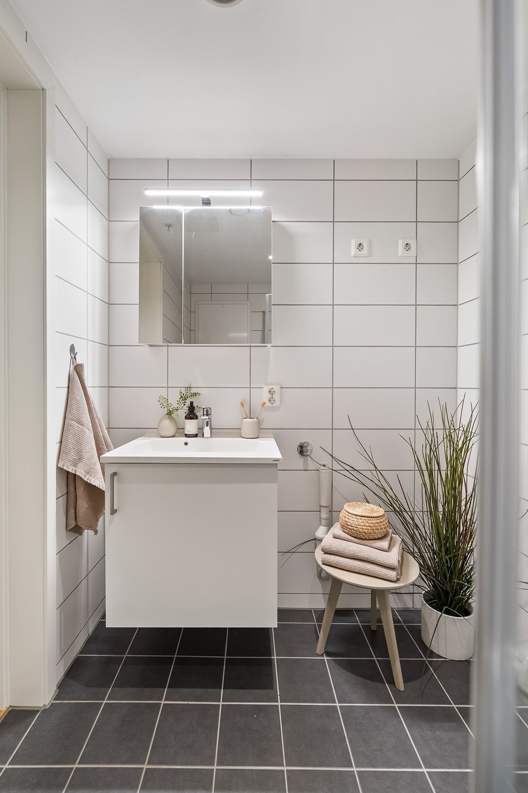 Innredningen består av speilskap, baderomsinnredning med finert front og heldekkende servant. Videre er badet utstyrt med veggmontert toalett og et praktisk dusjhjørne med innfellbare glassvegger. Det er også opplegg for vaskemaskin. Galleribilde