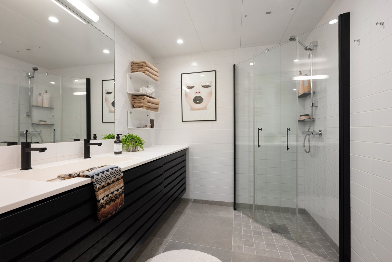 Baderommet ved hovedsoverommet er av god størrelse, og er vakkert innredet med dobbel heldekkende servant på benkeseksjon. Påkostede dusjdører med sort profil. Galleribilde