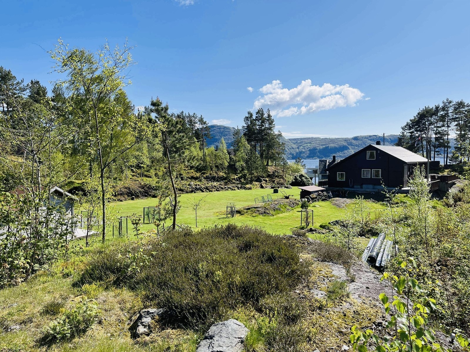 Delvis naturtomt som består av fjell og opparbeidet plen. Galleribilde