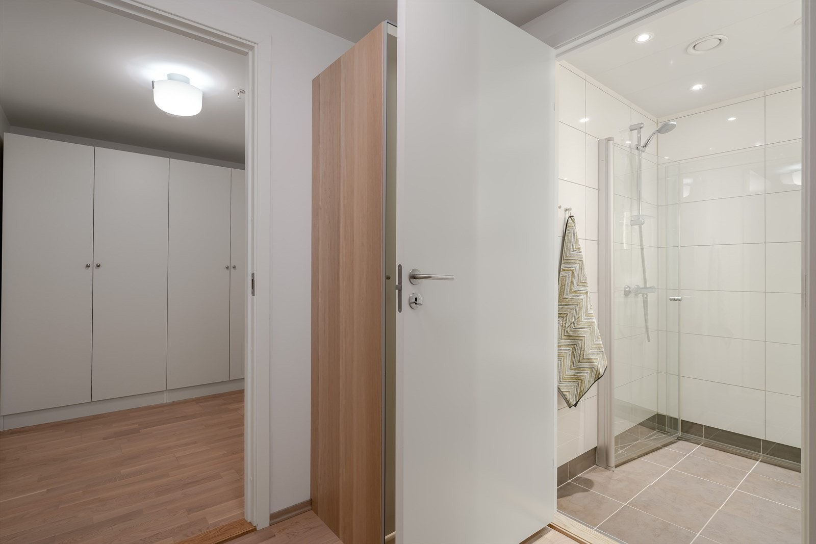 Badene har fliser på gulv og vegger og spotter i tak. Galleribilde