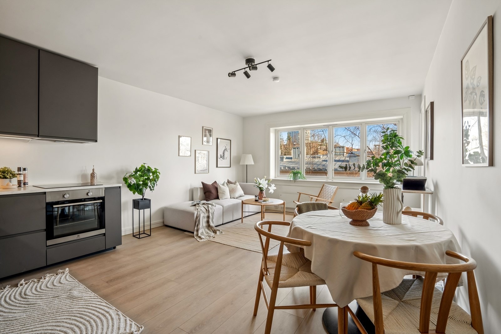 Stuens gode størrelse gjør det enkelt å møblere i flere soner med god plass for en stor sofaseksjon med tilhørende møblement, i tillegg til en egen sone med et hyggelig spisebord Galleribilde