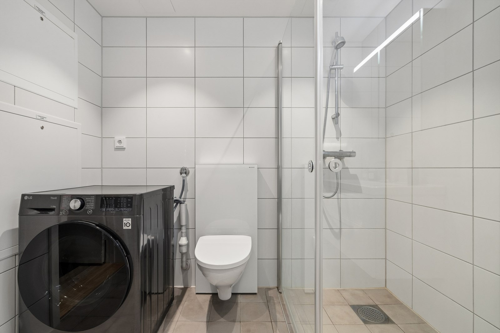 Vegg hengt toalett og opplegg for vaskemaskin. Galleribilde