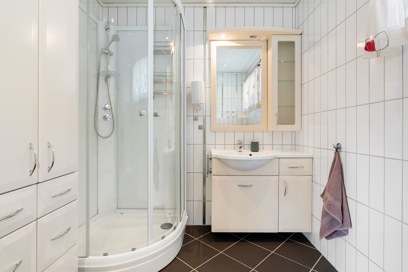 Badet inneholder dusjkabinett, servant med speil, wc og skap. Galleribilde