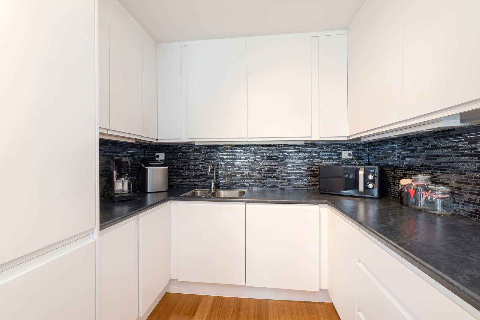 Romslig innredning med god benkplass og rikelig med over- og underskap. Integrerte hvitevarer. Galleribilde