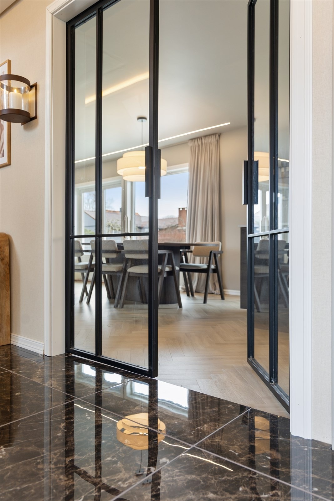 Flislagt gulv i entréen står i stilfull kontrast til parketten i stuen. Galleribilde