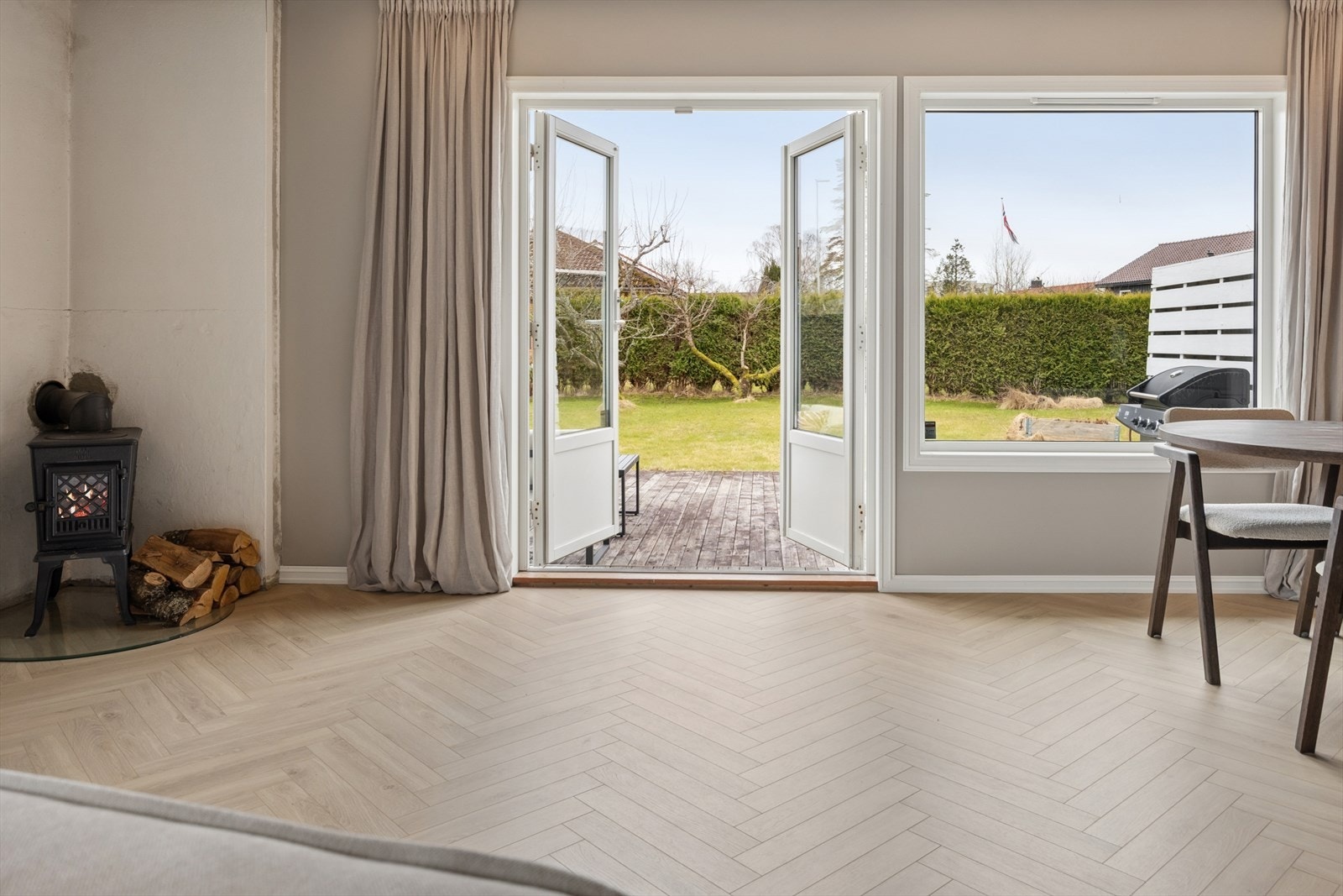 Doble dører åpner opp mot hagen og terrassen, og visker ut skillet mellom inne og ute. Galleribilde