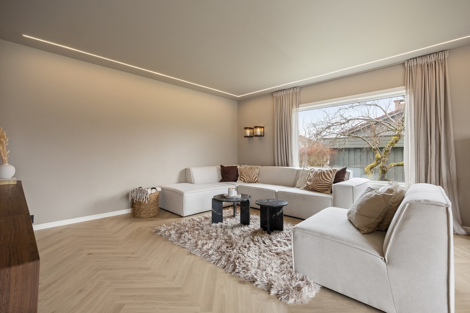 På gulvet ligger det elegant parkett som gir rommet et varmt og eksklusivt preg, mens en moderne LED-lyslist i himlingen tilfører et stilrent og behagelig lys. Galleribilde