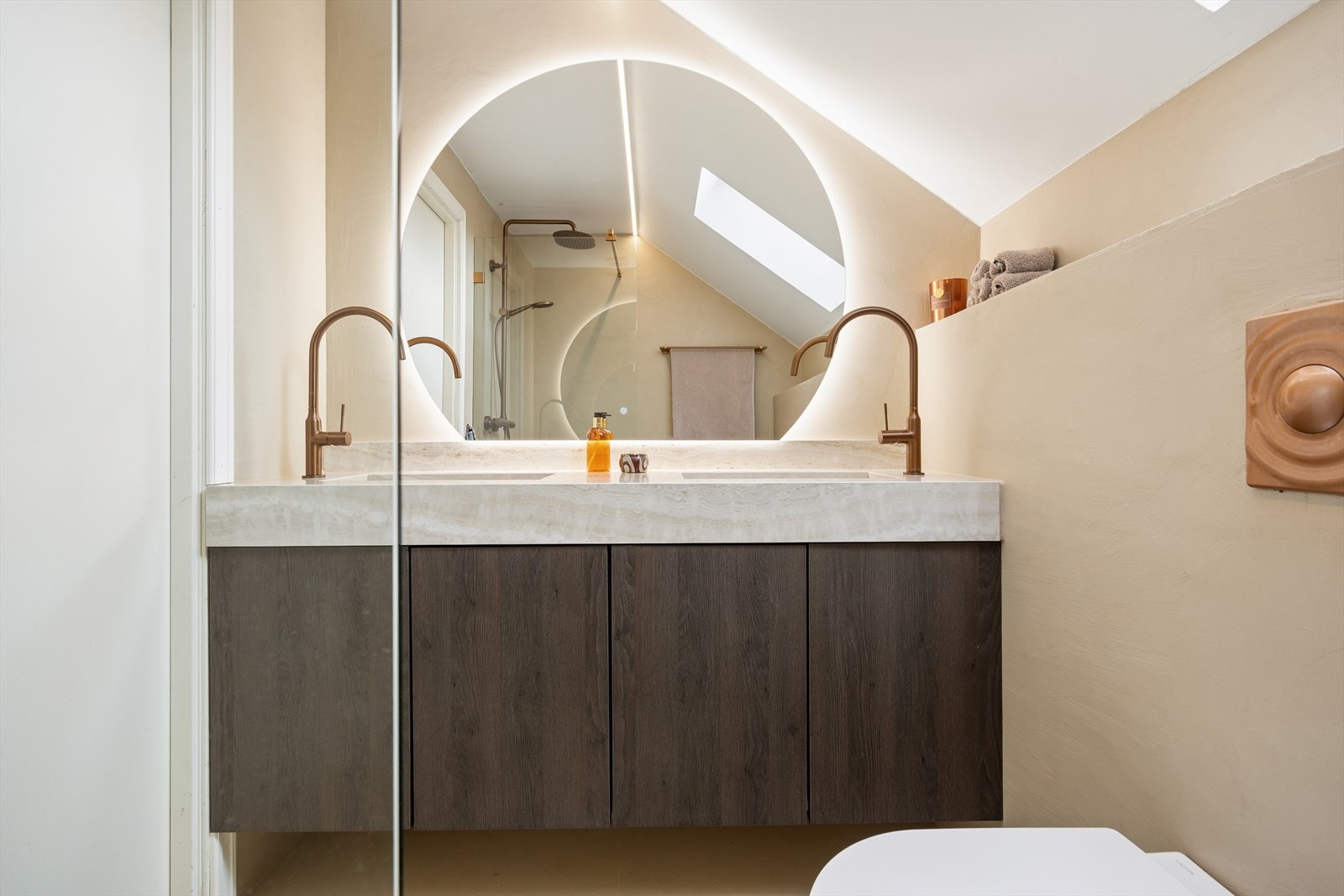 Badet er utstyrt med elektriske varmekabler i gulvet, vegghengt toalett og en dobbel servantinnredning. Galleribilde