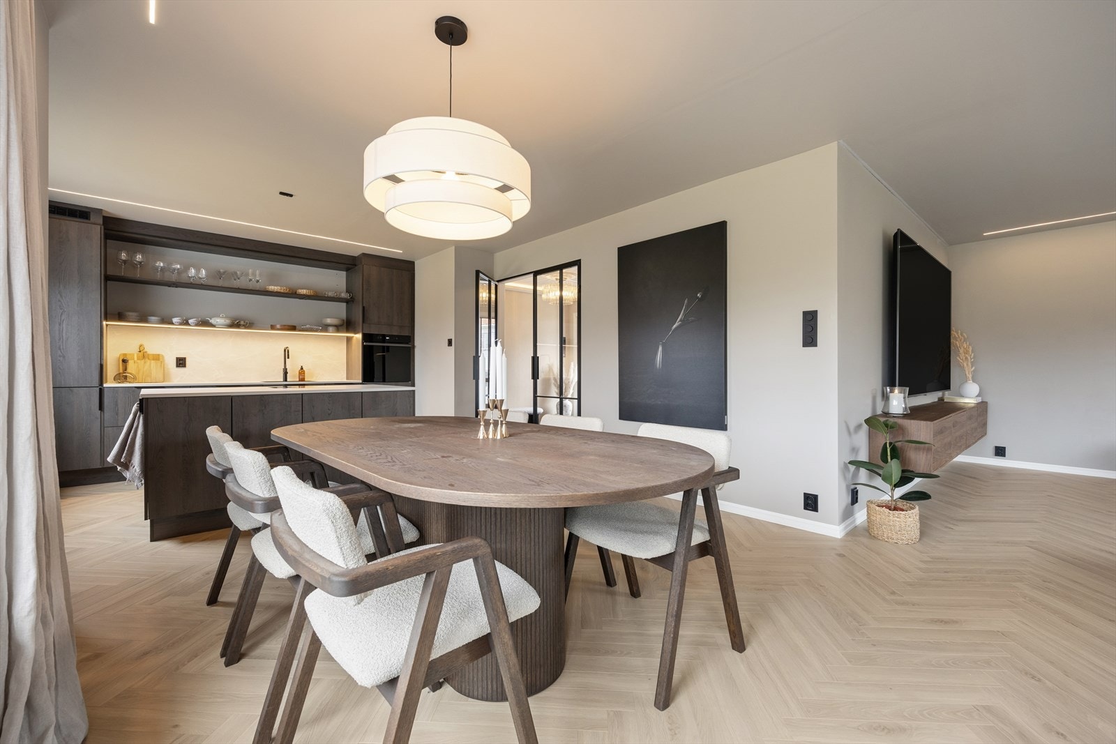 Boligen byr på en moderne, åpen stue- og kjøkkenløsning som gir en romslig atmosfære med godt plass til både sofagruppe og en innbydende spiseplass. Galleribilde