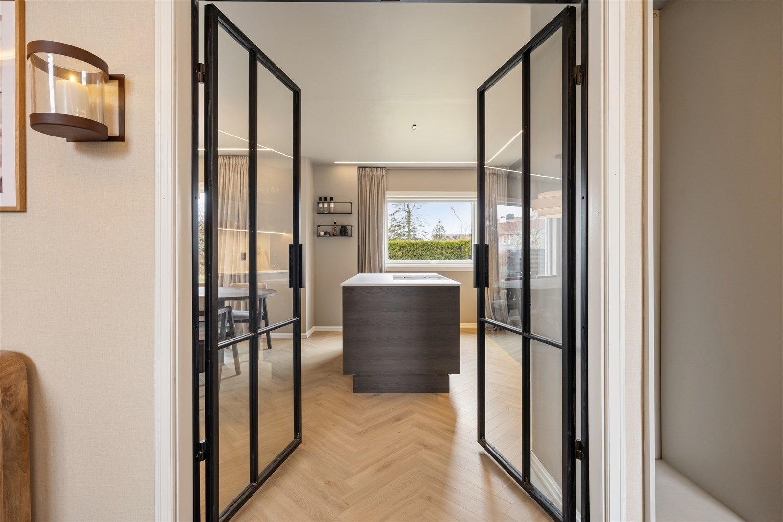 En glassdør skiller gangen fra stue- og kjøkkenområdet, og bidrar til en lys og åpen romfølelse. Galleribilde