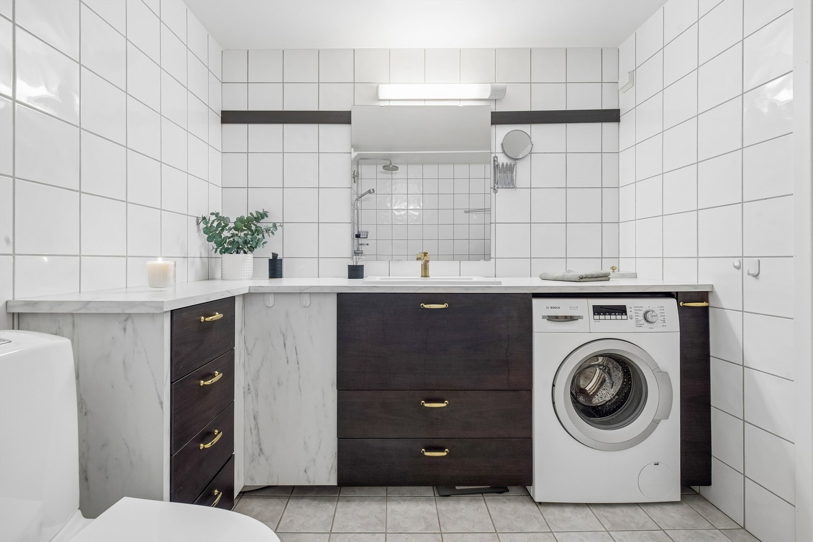 Badet har flislagt gulv med elektriske varmekabler og opplegg for vaskemaskin. Galleribilde