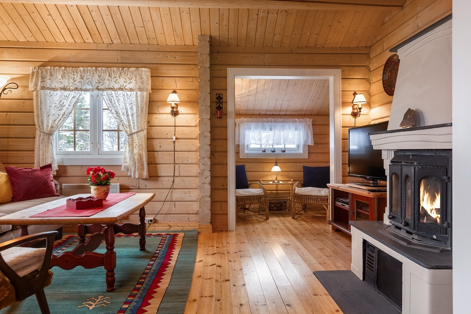 En elementpeis med innsats sørger for lun og god varme til hytta, og de mange vindusflatene inviterer naturen inn i alle rom. Galleribilde