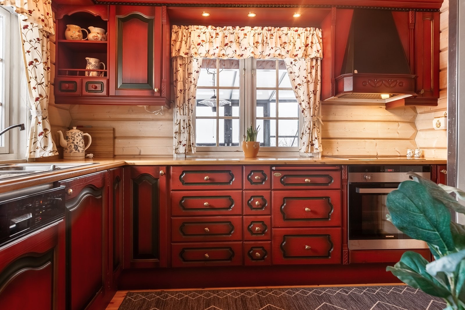 Kjøkkenet har malt innredning av heltre med profilerte fronter i over-og underskap, laminat benkeplate og oppvaskkum med kran av stål. Galleribilde