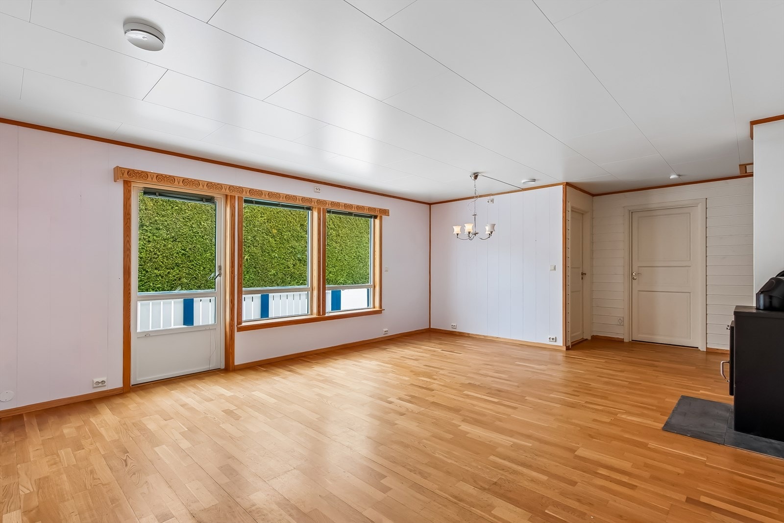 Romslig stue med parkettgulv og direkte utgang til en av boligens to terrasser. Det er varmekabler i stue. Galleribilde