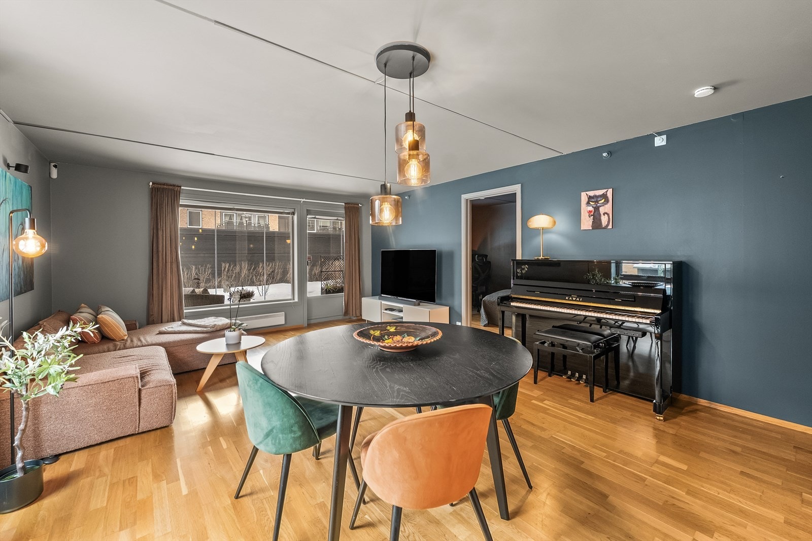 Spisebordet har en naturlig plassering i rommet, sentrert under taklampen som markerer spiseplassen på en fin måte. Galleribilde