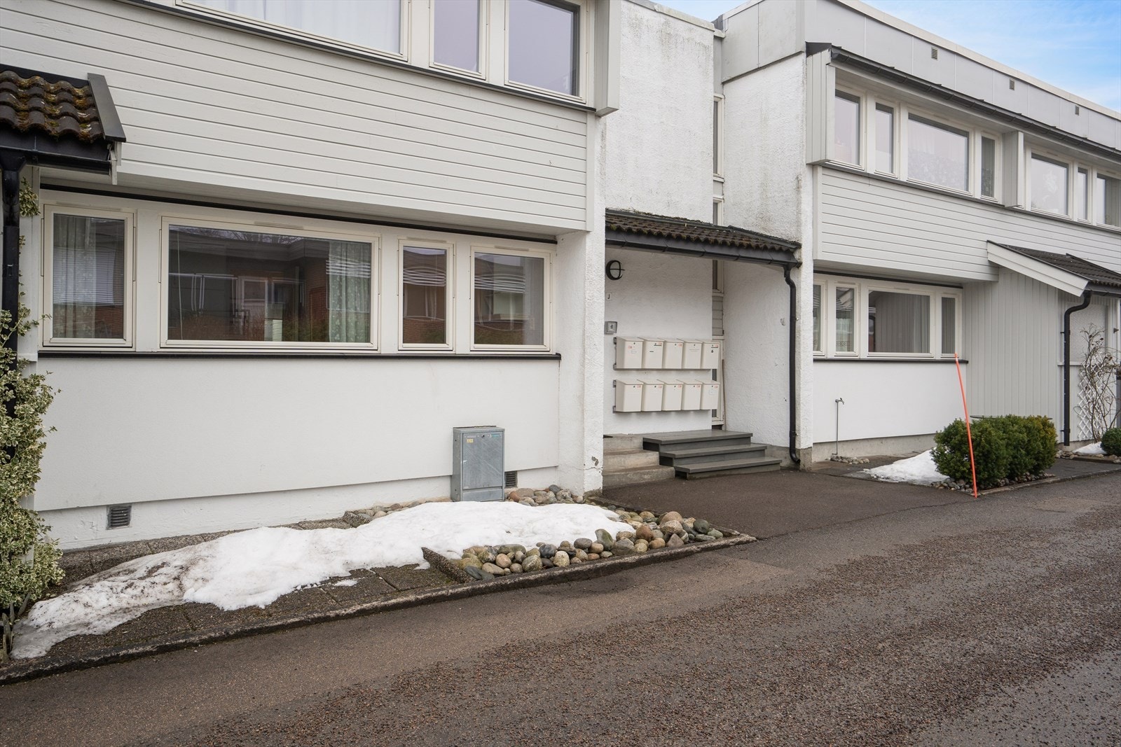 Bygget har et trivelig inngangsparti og leiligheten disponerer uteplass her. Galleribilde