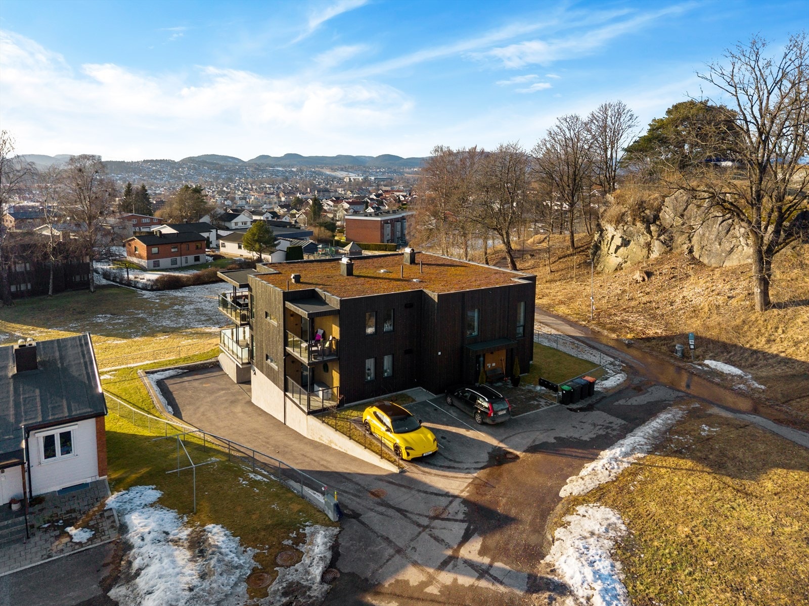 Det er etablert en parkeringsplass ved inngangspartiet med 3 gjesteparkeringsplasser. Kjørebanen ned mot garasjekjeller har varmekabler og asfalt. Galleribilde