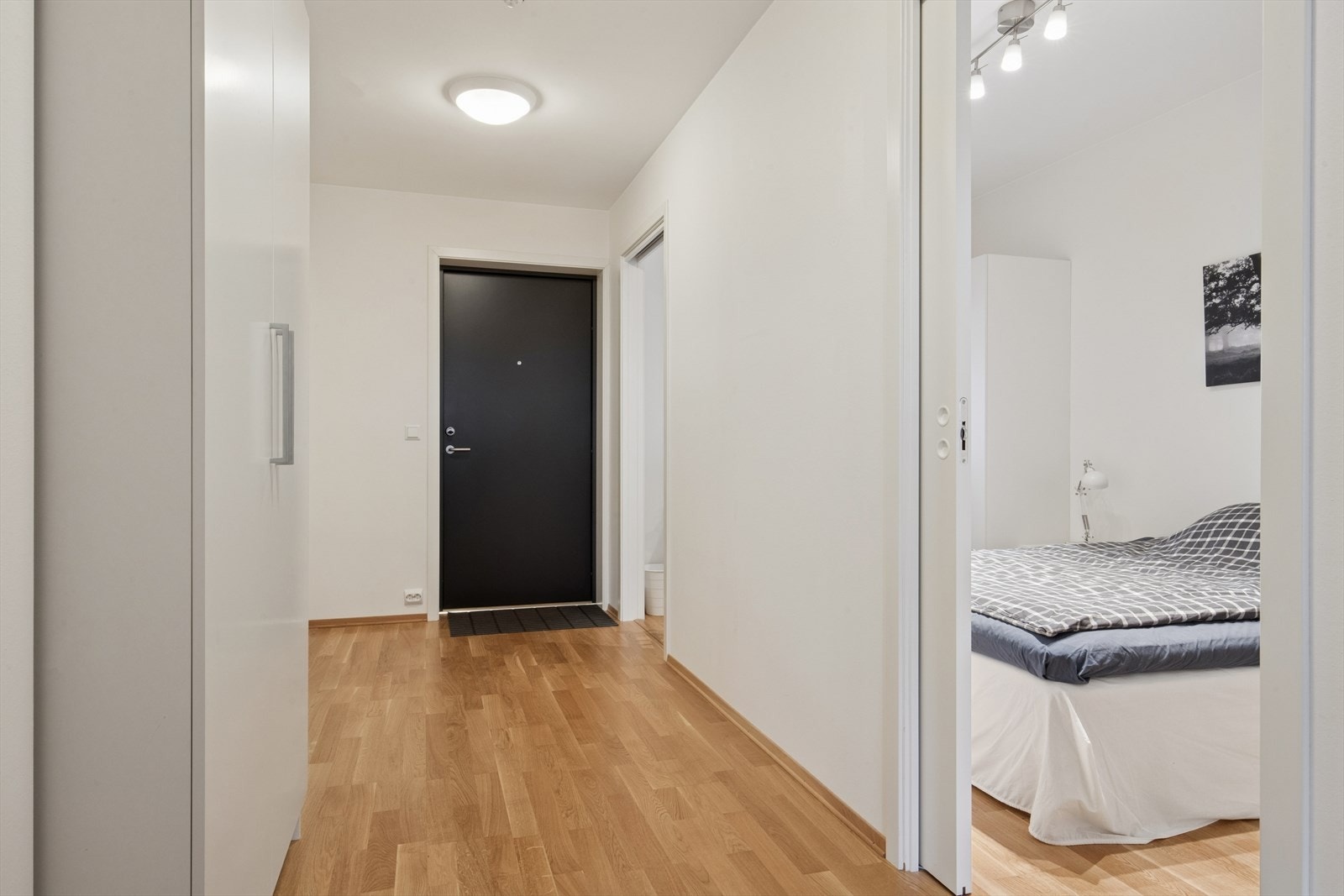 Velkommen inn i en lys entré med parkettgulv som går igjen i store deler av boligen. Galleribilde