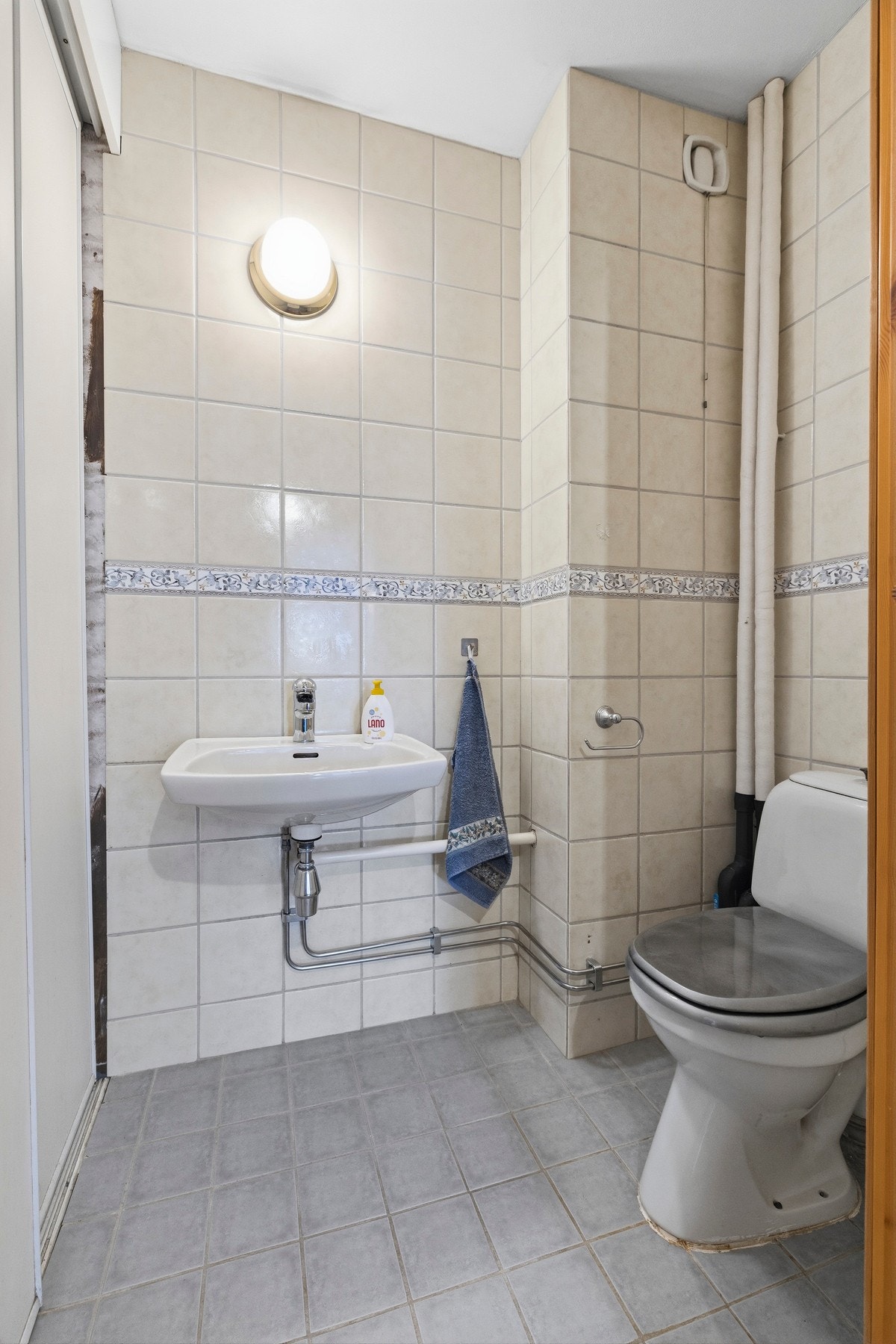 Toalettet er utstyrt med gulvstående toalett og servant i porselen Galleribilde