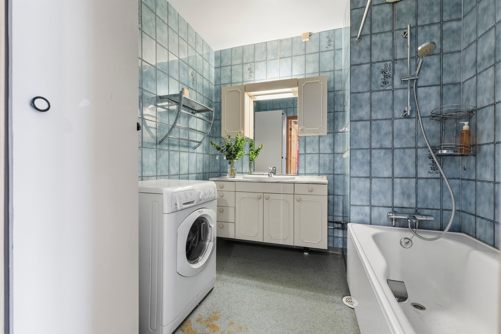 Badet har flislagte vegger og vinylbelegg på gulvet Galleribilde