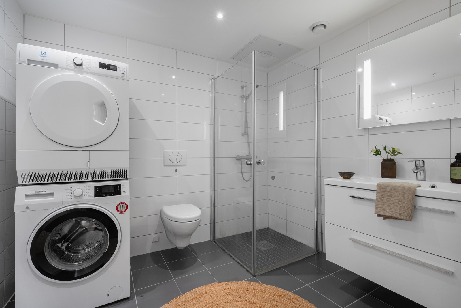 Tidløst helfliset bad med opplegg for vaskemaskin og tørketrommel. Galleribilde