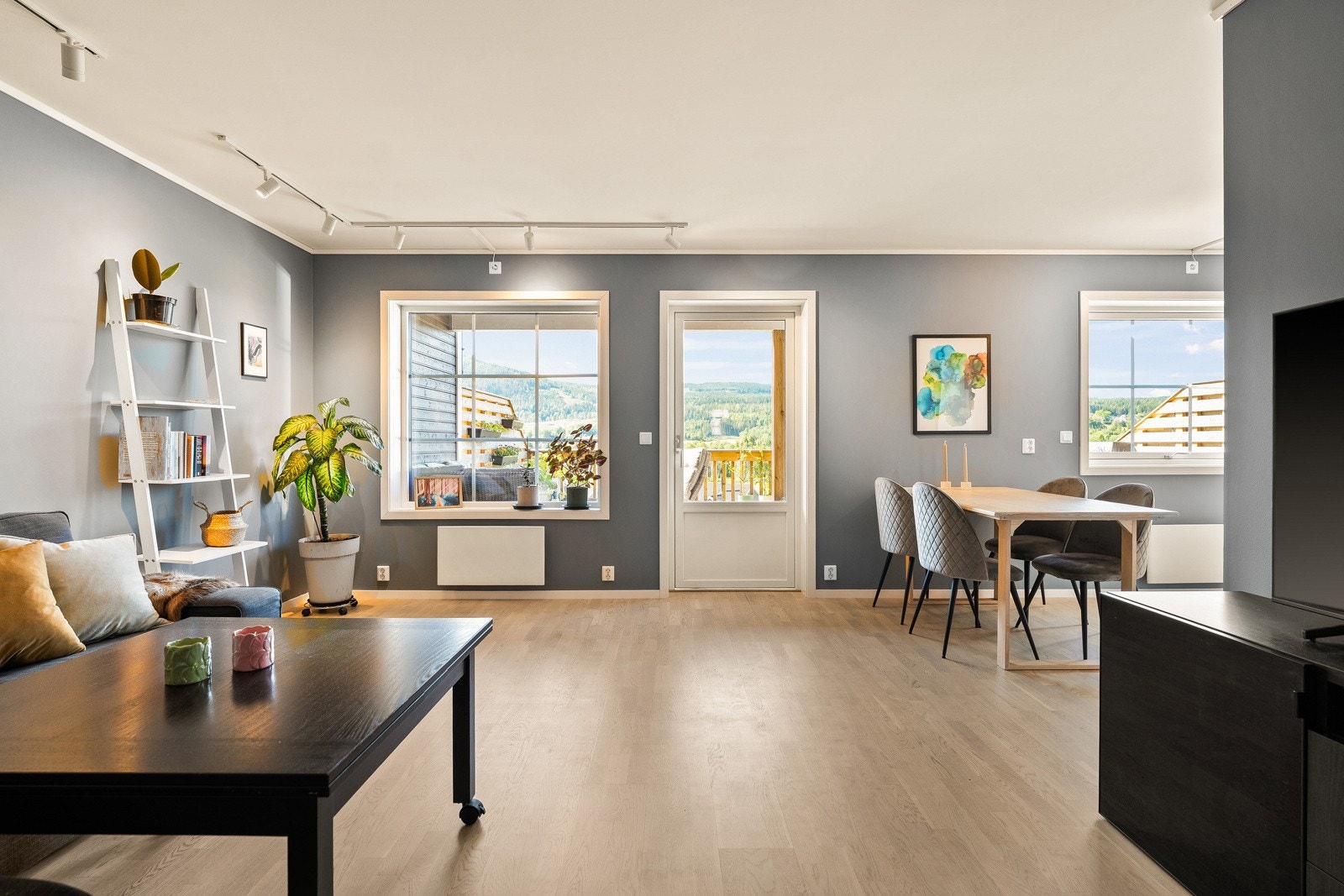 Det luftige rommet har et naturlig skille mellom de ulike sonene, og i tilknytning til kjøkkenet er det plass til et spisebord. Galleribilde