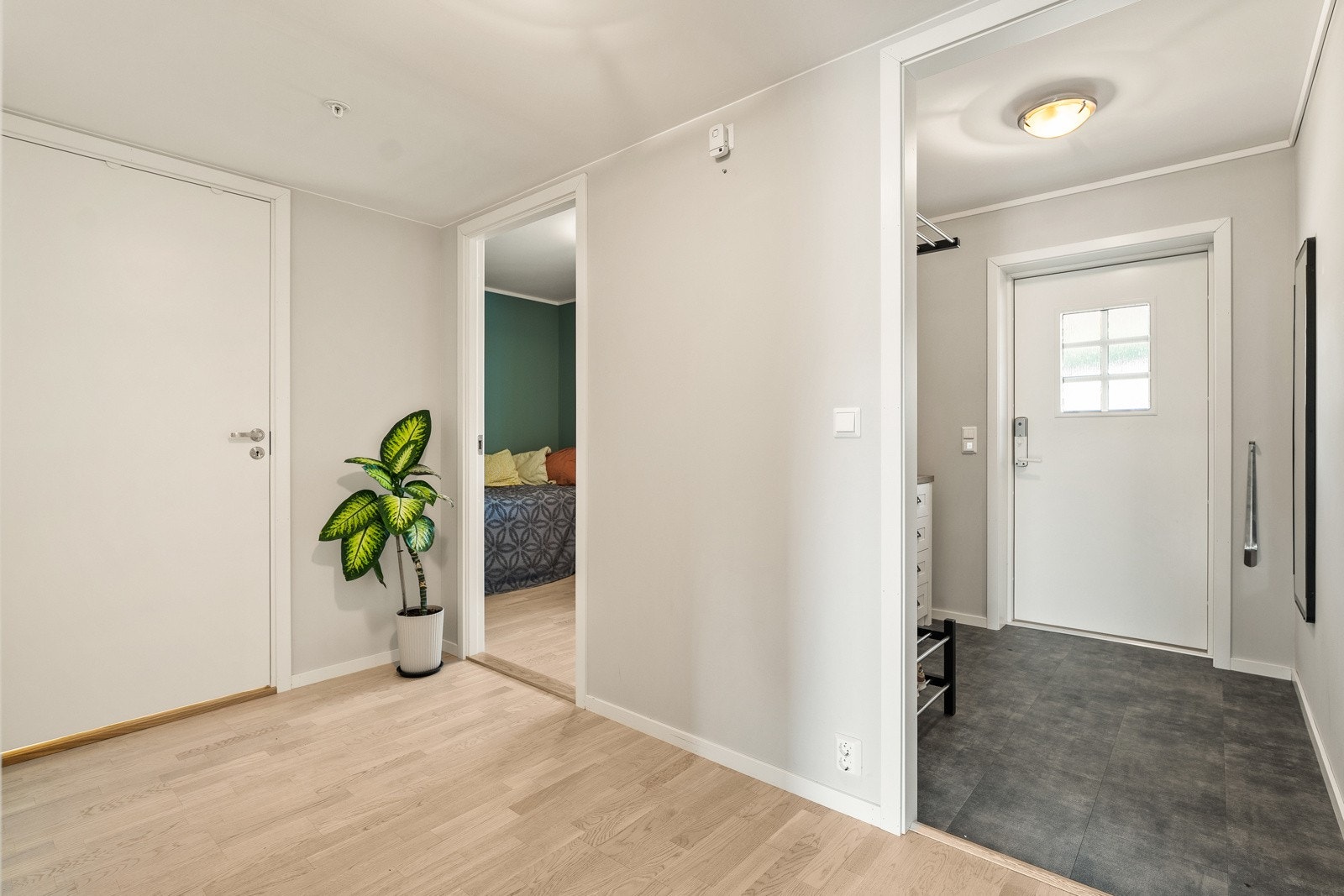 Bilde fra gangen med soverom 1 inn til venstre i bildet, entrè til høyre i bildet. Varmekabler på bad og entrè. Galleribilde